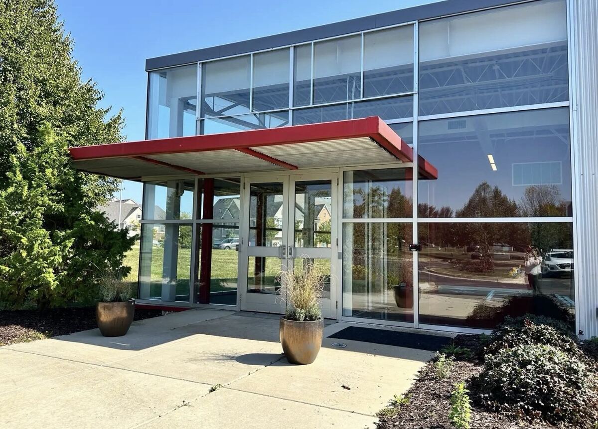 Steel entry awning with metal deck over storefront doors