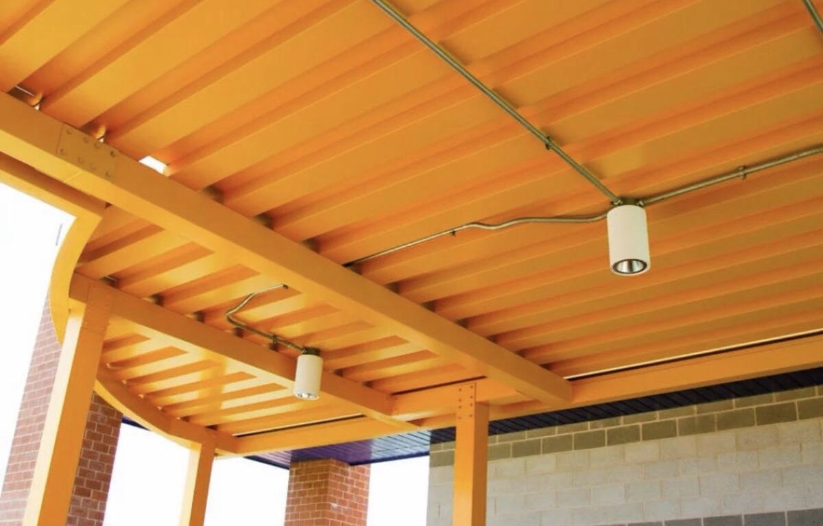 Painted structural steel canopy with exposed beams and lighting